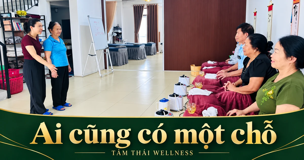 Khung cảnh có người ngồi và người đứng bên cạnh trong không gian sinh hoạt chung.