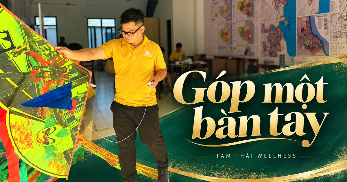 Một người lớn chuẩn bị với cánh diều màu xanh.